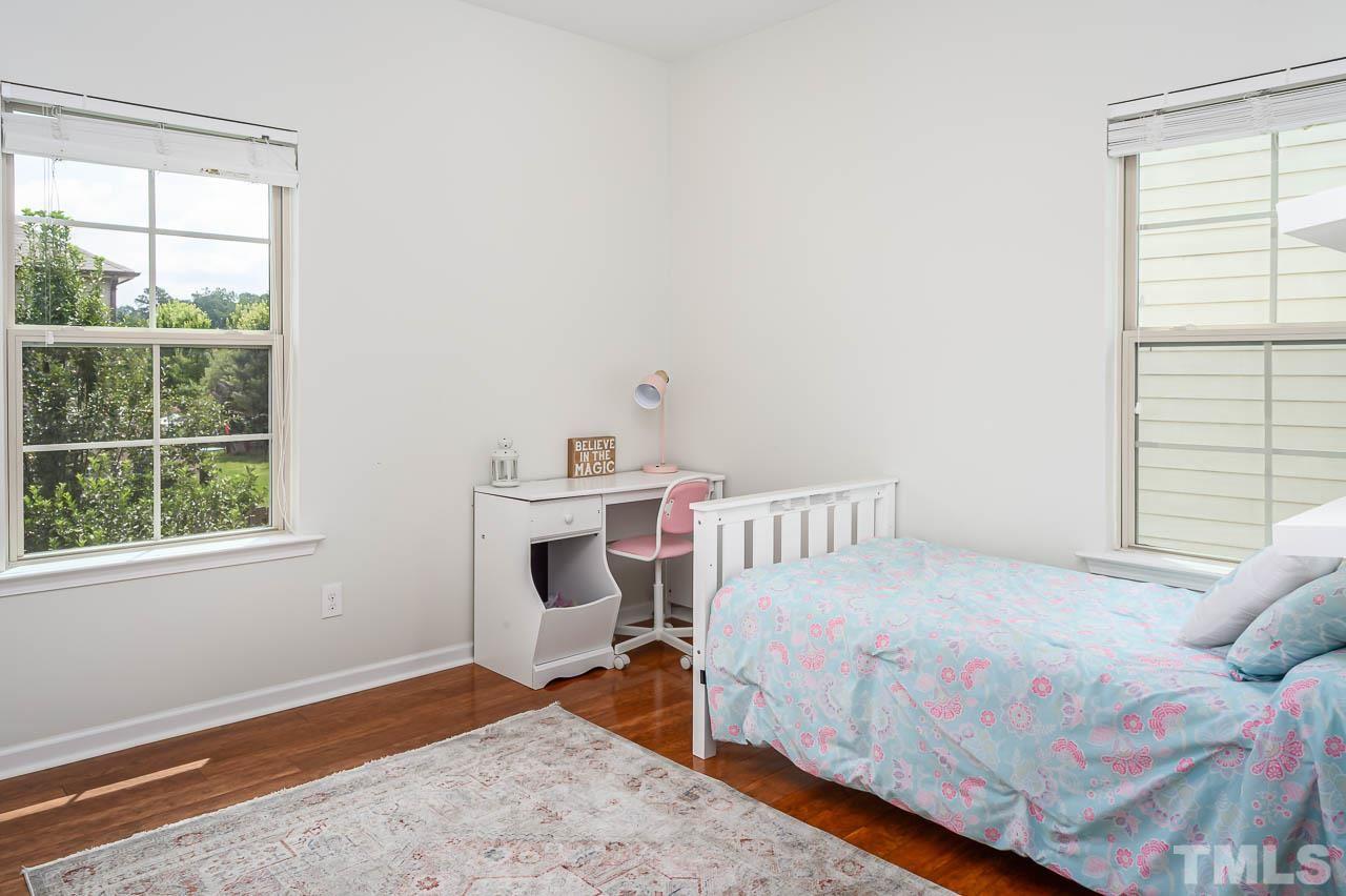 2401 Pilsley Road Apex, NC 27539 - Photo 22 of 28 a bedroom with a bed a table and windows