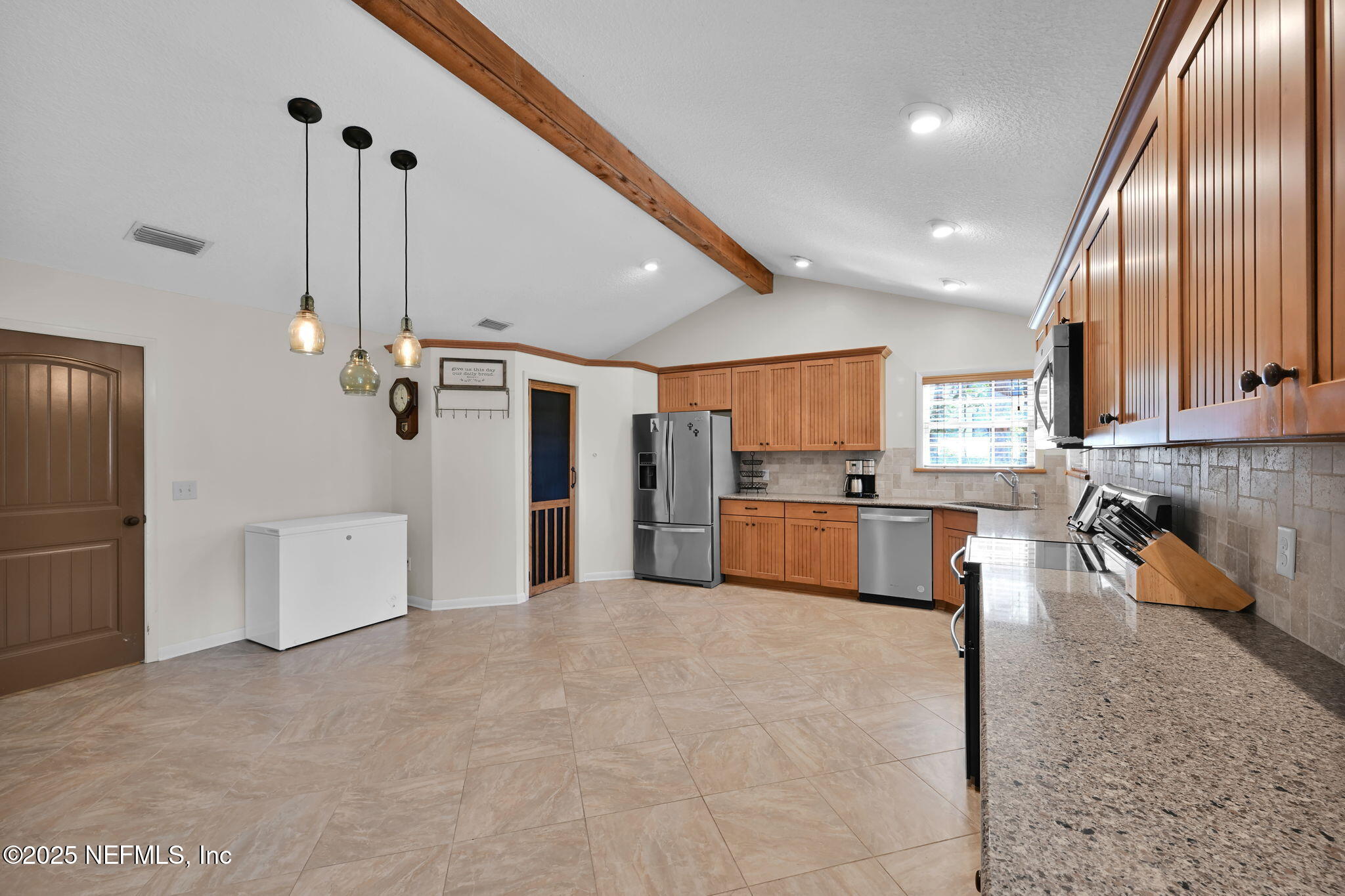 3541 Pacetti Road St. Augustine, FL 32092 - Photo 36 of 74 a large white kitchen with stainless steel appliances kitchen island granite countertop a refrigerator and a sink