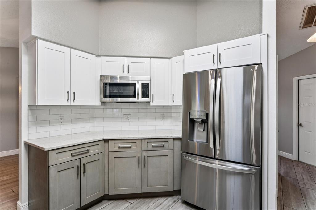 8357 Matthew Drive New Port Richey, FL 34653 - Photo 17 of 78 a kitchen with stainless steel appliances granite countertop a refrigerator and a microwave