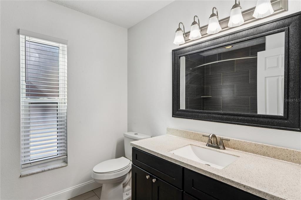 8357 Matthew Drive New Port Richey, FL 34653 - Photo 39 of 78 a bathroom with a granite countertop toilet sink and mirror