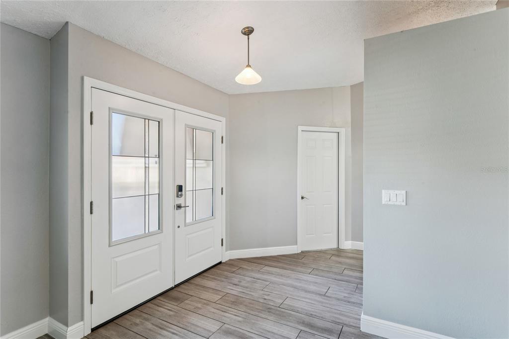 8357 Matthew Drive New Port Richey, FL 34653 - Photo 7 of 78 a view of an empty room with wooden floor and a window