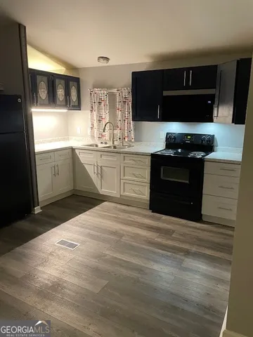 a kitchen with stainless steel appliances kitchen island granite countertop a stove a sink and a microwave