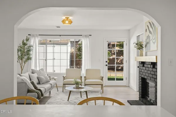 a dining room with furniture a fireplace and wooden floor