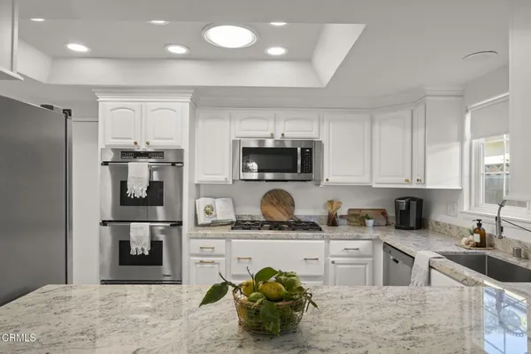 a kitchen with cabinets appliances a sink and a window