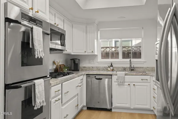 a kitchen with granite countertop stainless steel appliances stove and cabinets