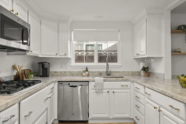 a kitchen with stainless steel appliances granite countertop a refrigerator and a sink