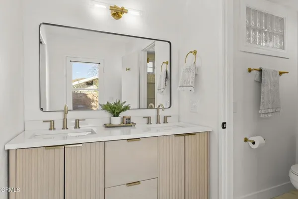 a en suite bathroom with a double vanity sink and a mirror
