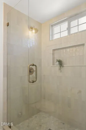 a bedroom with two beds and a large mirror next to a window