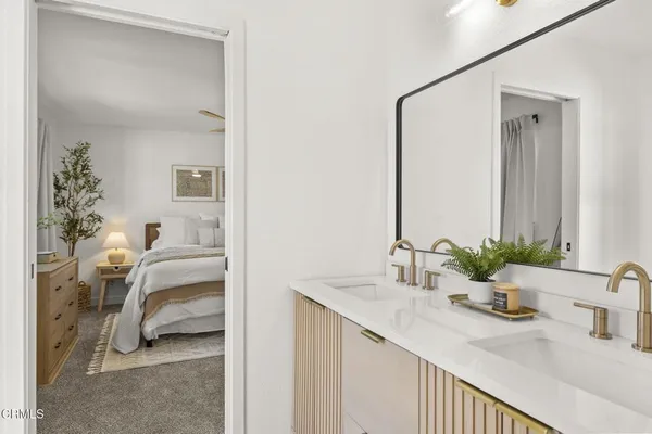 a bedroom with two beds and a lamp on dresser
