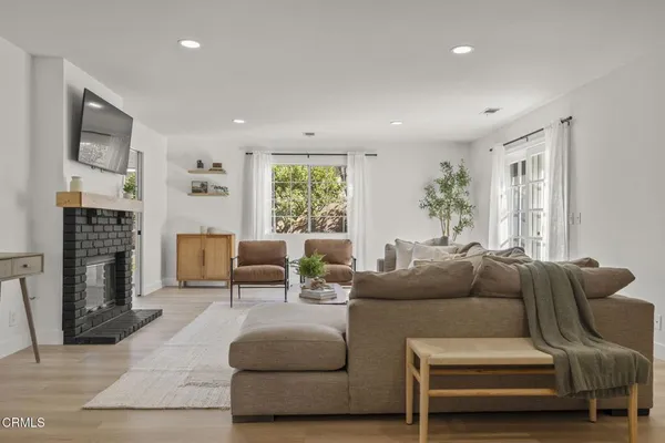 a living room with furniture a fireplace and a large window