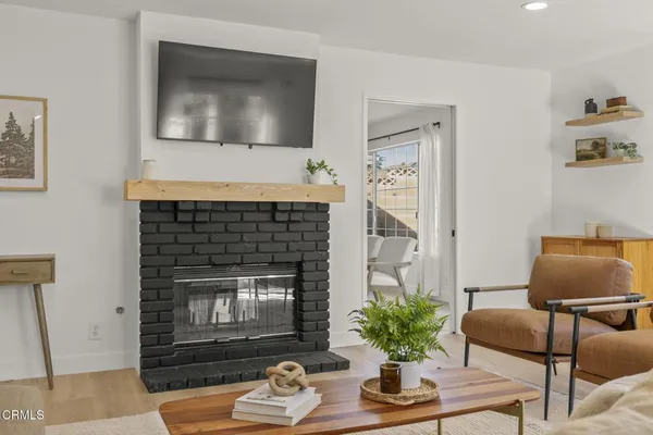 a living room with furniture a flat screen tv and a fireplace