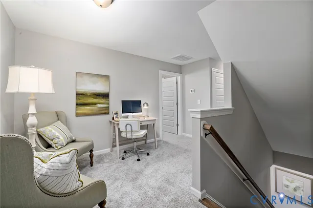 a living room with furniture a flat screen tv and kitchen view
