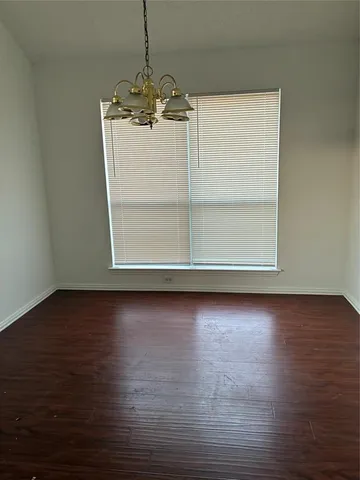 a view of a room with wooden floor and window