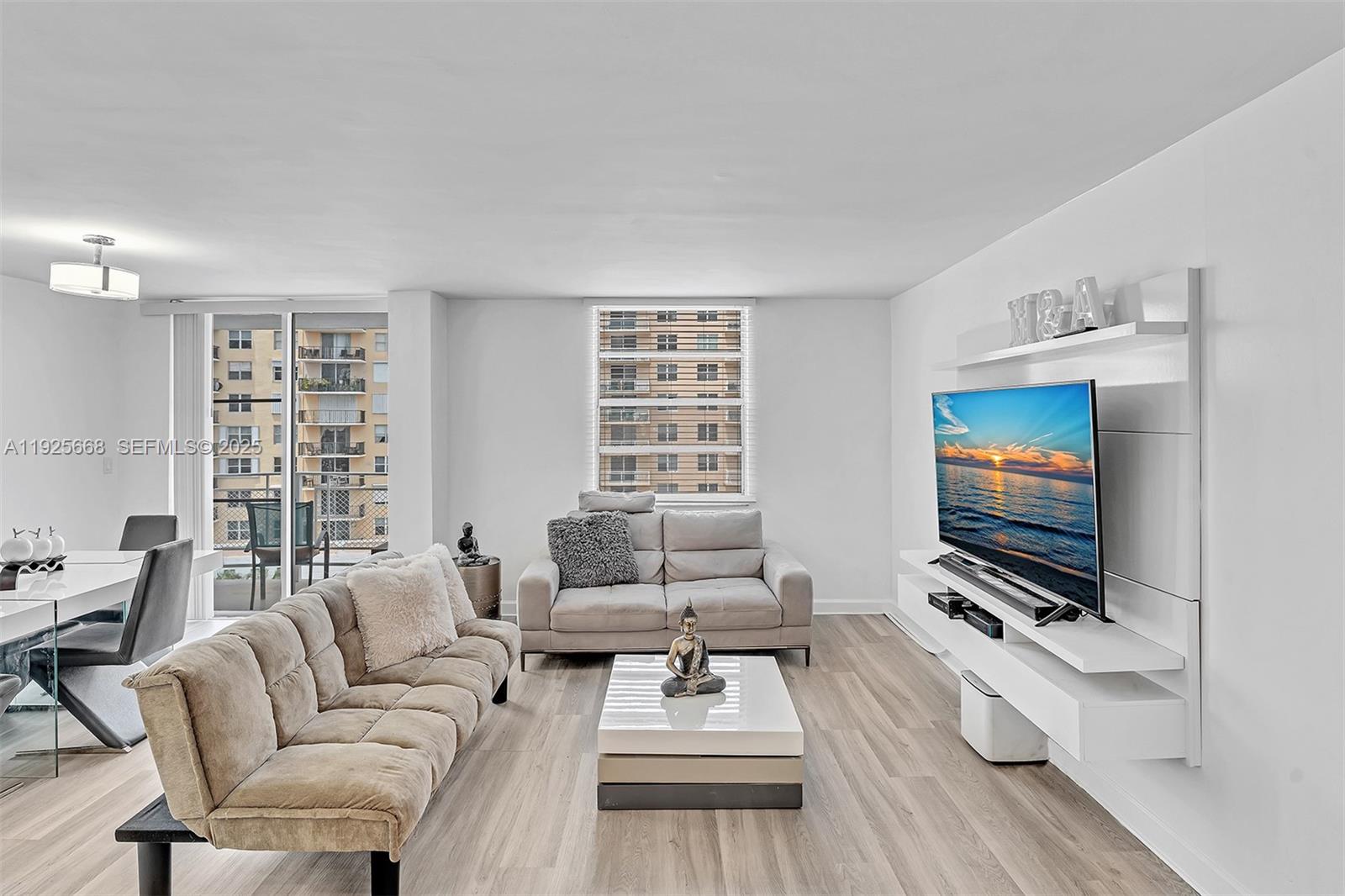 430 Golden Isles Drive, Unit 803 Hallandale Beach, FL 33009 - Photo 11 of 48 a living room with furniture a flat screen tv and a window