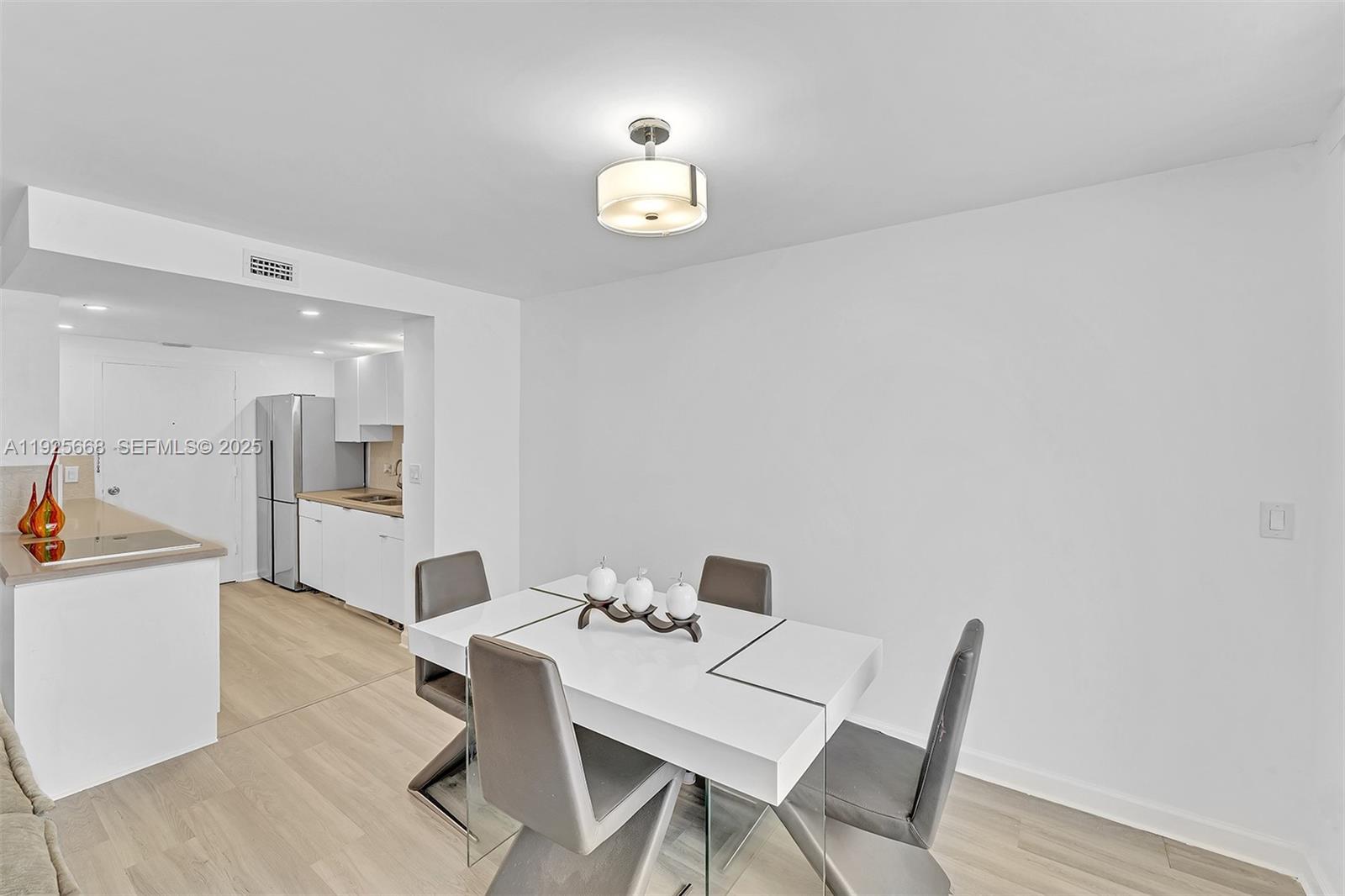 430 Golden Isles Drive, Unit 803 Hallandale Beach, FL 33009 - Photo 15 of 48 a view of a dining room with furniture and a chandelier
