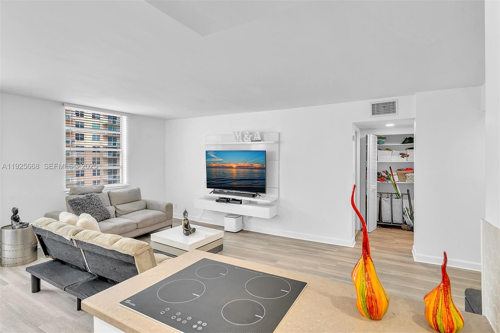 430 Golden Isles Drive, Unit 803 Hallandale Beach, FL 33009 - Photo 23 of 48 a living room with furniture and a flat screen tv