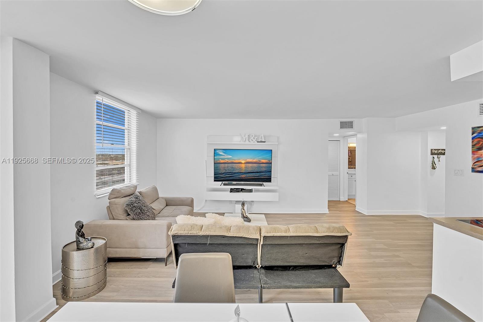 430 Golden Isles Drive, Unit 803 Hallandale Beach, FL 33009 - Photo 25 of 48 a living room with couches and a flat screen tv