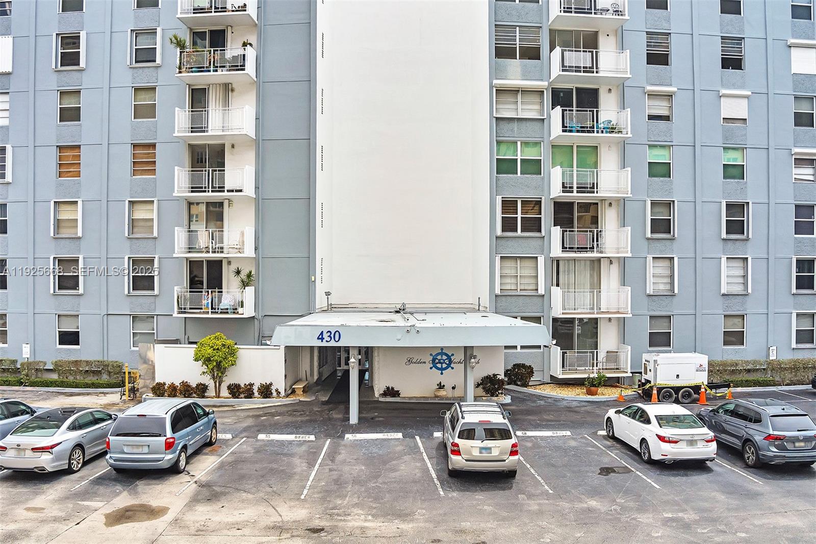 430 Golden Isles Drive, Unit 803 Hallandale Beach, FL 33009 - Photo 37 of 48 a car parked in front of a building