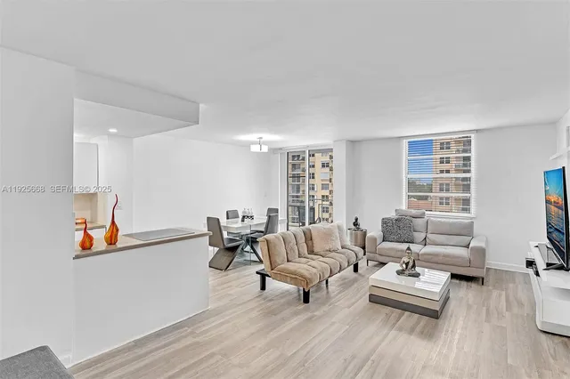 a living room with furniture a flat screen tv and a window