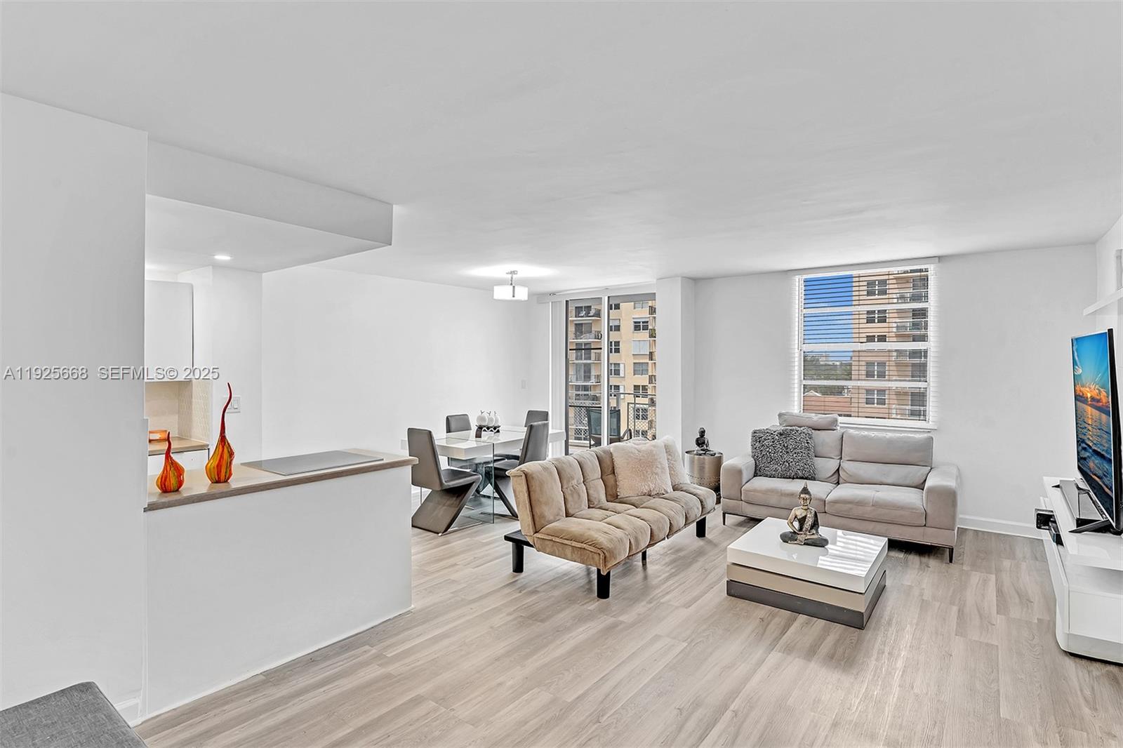 430 Golden Isles Drive, Unit 803 Hallandale Beach, FL 33009 - Photo 10 of 48 a living room with furniture and a wooden floor