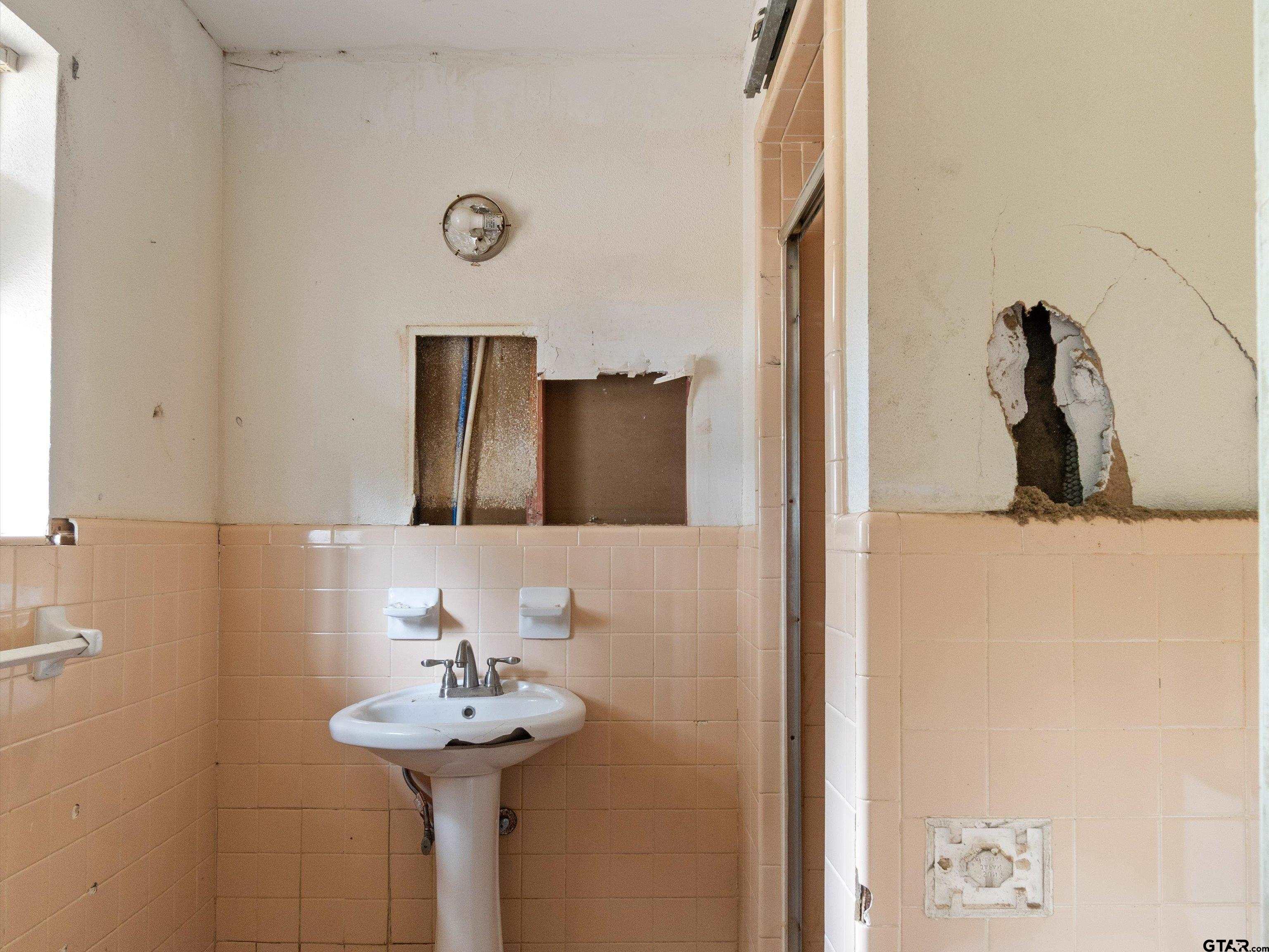 175 Stevens Street Gilmer, TX 75645 - Photo 22 of 25 a bathroom with a sink and a mirror