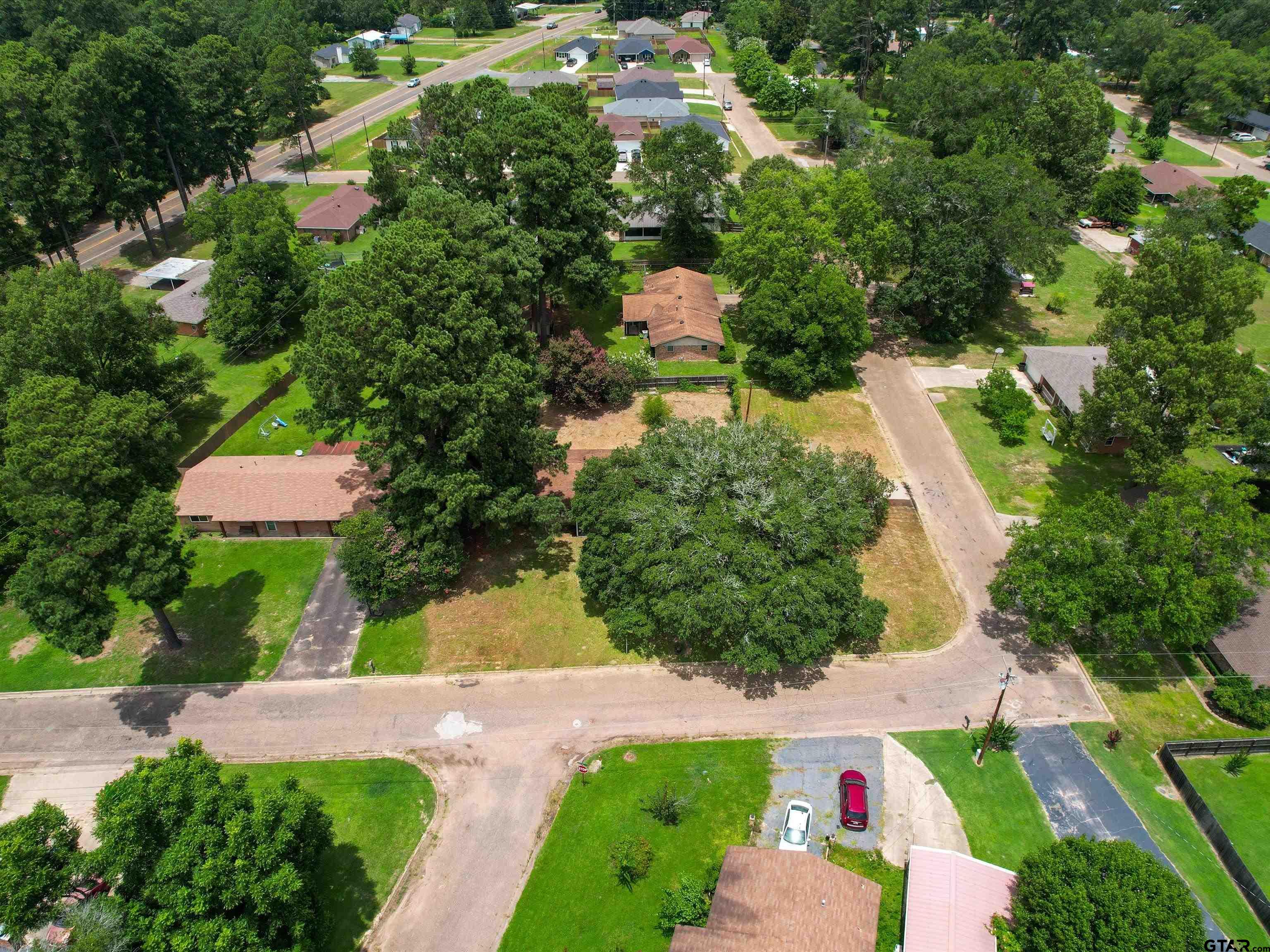 175 Stevens Street Gilmer, TX 75645 - Photo 3 of 25 an aerial view of residential house with outdoor space and trees all around