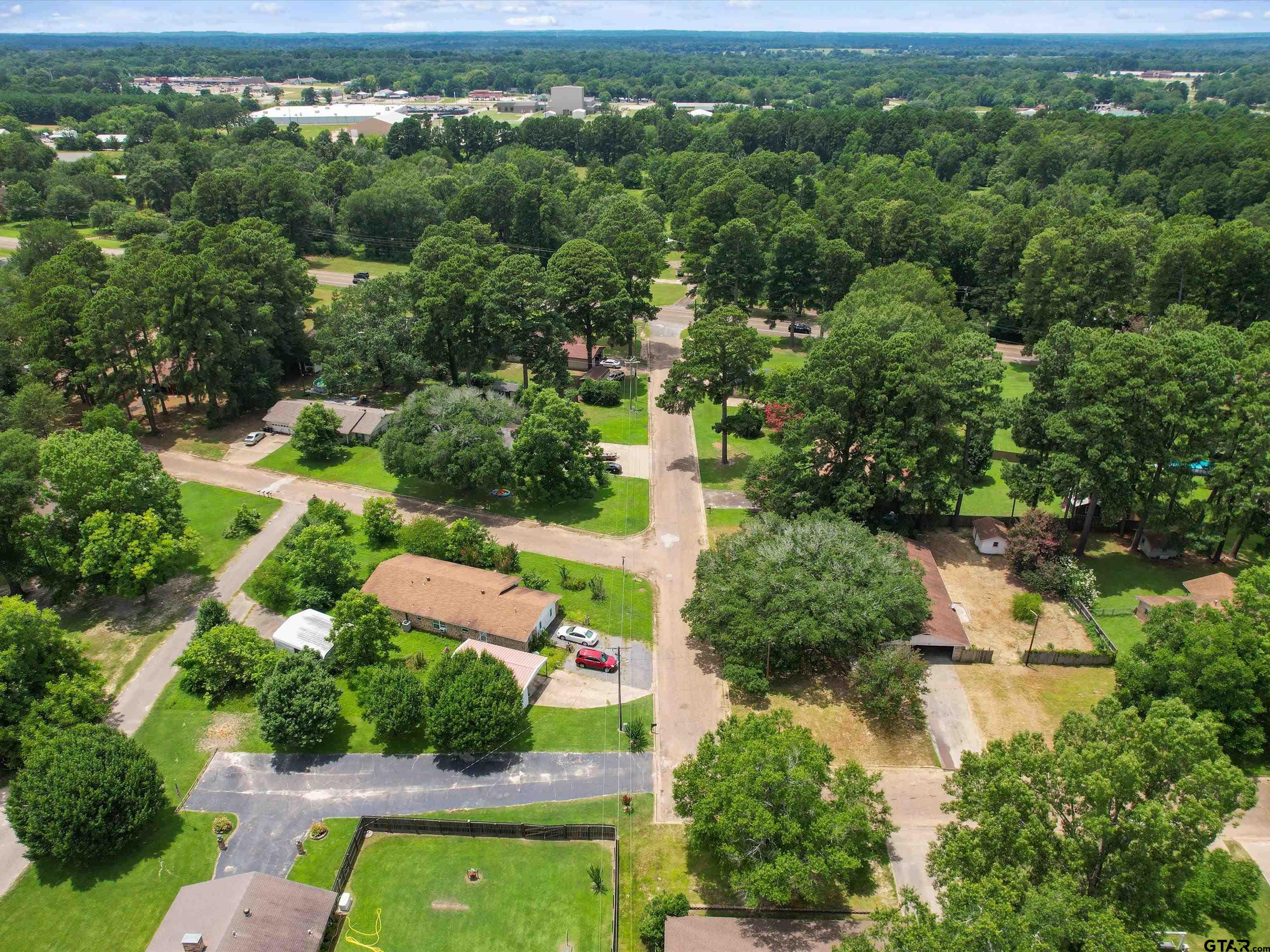 175 Stevens Street Gilmer, TX 75645 - Photo 6 of 25 an aerial view of residential houses with outdoor space and trees