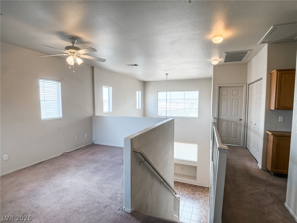 228 Positive Point Street Henderson, NV 89012 - Photo 13 of 27 An airy loft area with a ceiling fan, offering versatile living space with natural illumination.