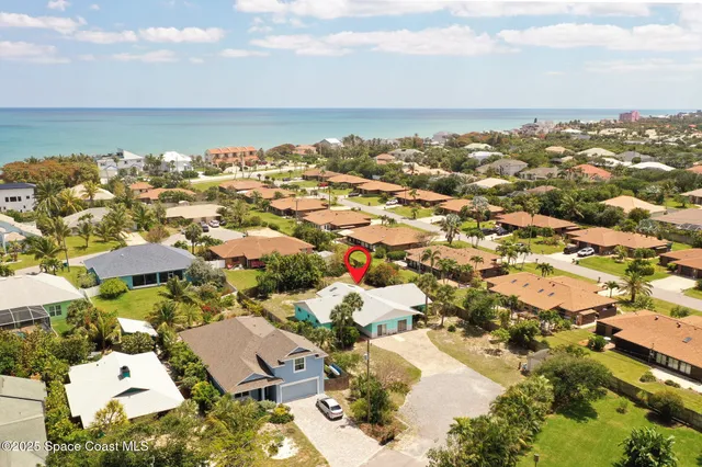 an aerial view of a city with lots of residential buildings and ocean view in back