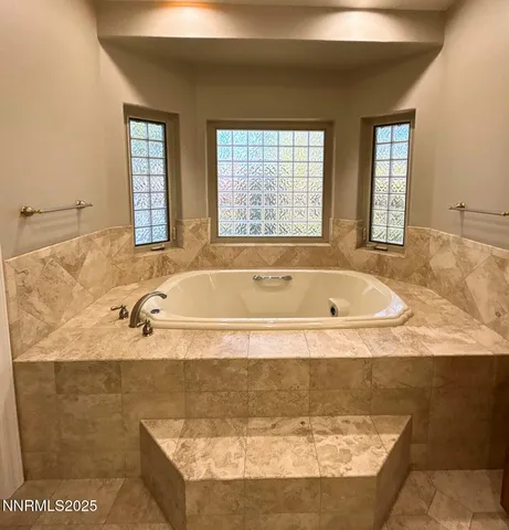 a bath tub sitting in a bathroom next to a window