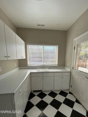 a kitchen with a sink a stove cabinets and a window