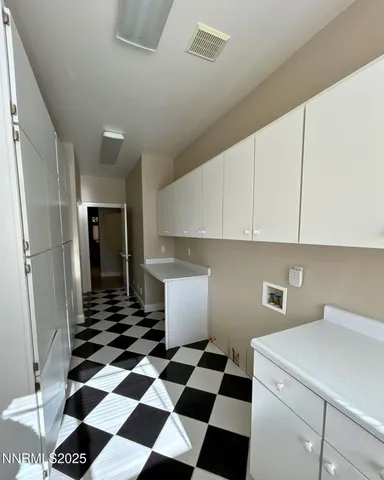 a kitchen with a checkered floor and white cabinets