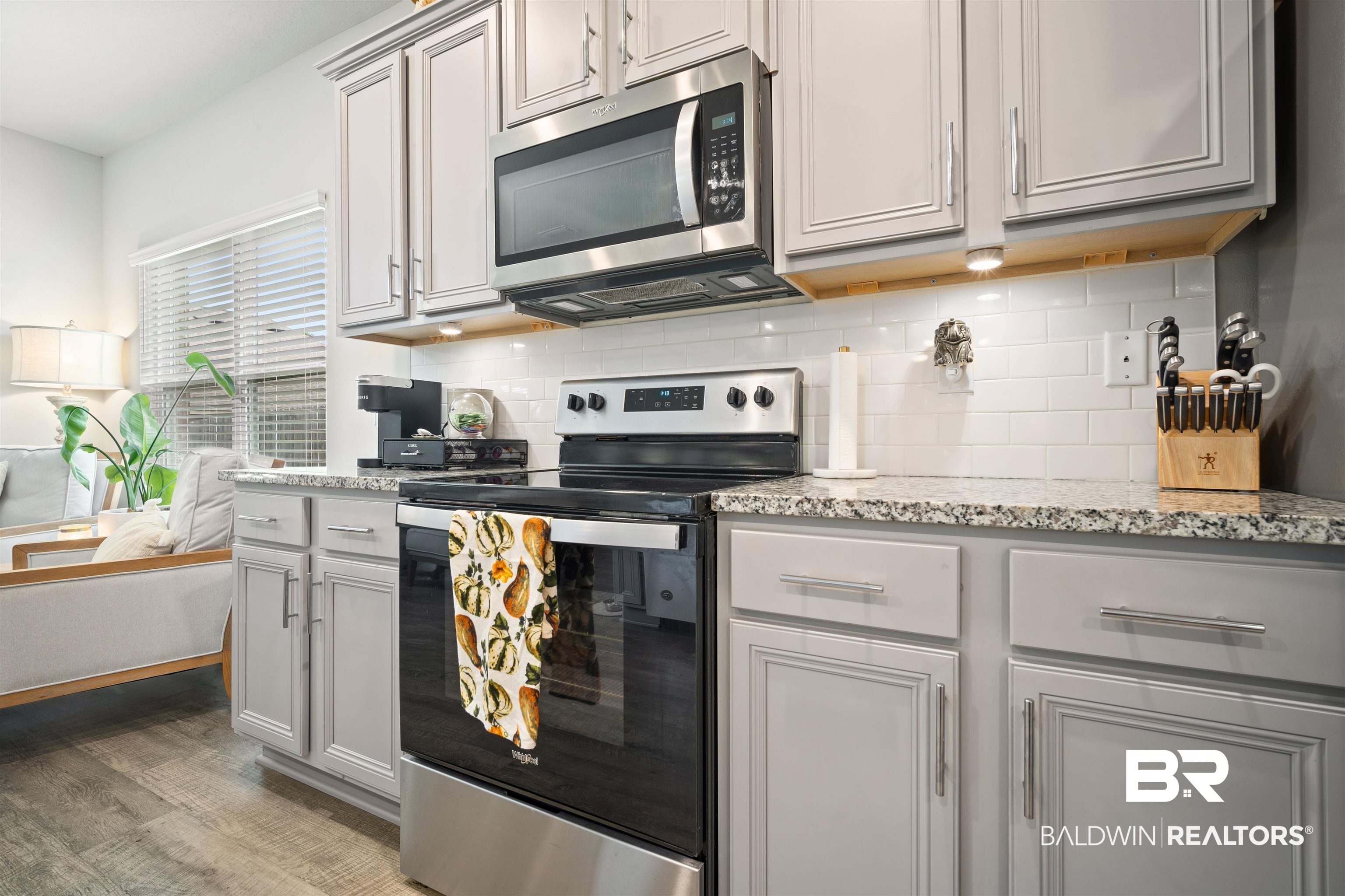10474 Loamy Avenue Mobile, AL 36695 - Photo 9 of 31 Kitchen featuring stainless steel appliances, gray cabinetry, tasteful backsplash, light stone countertops, and light wood finished floors