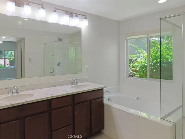 a bathroom with a granite countertop sink and a bathtub
