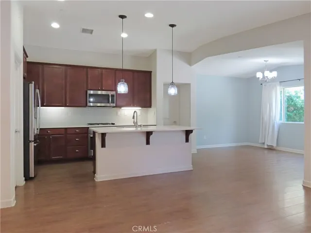 a kitchen with stainless steel appliances granite countertop a refrigerator a sink and a stove