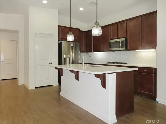 a kitchen with stainless steel appliances granite countertop a sink a stove and a refrigerator