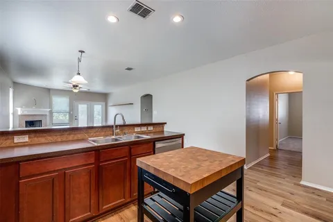 a kitchen with cabinets and wooden floor