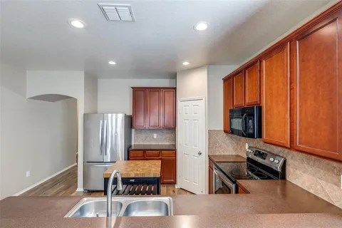 a kitchen with stainless steel appliances granite countertop a refrigerator and a stove top oven