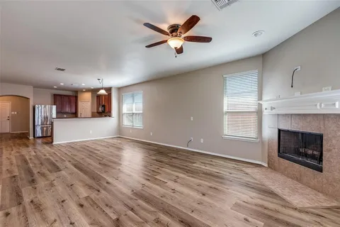 a view of an empty room with a fireplace and a window