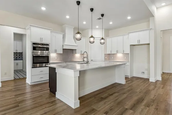 an open kitchen with white cabinets and stainless steel appliances