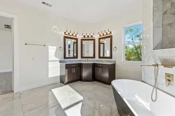 a bathroom with a tub sink and mirror