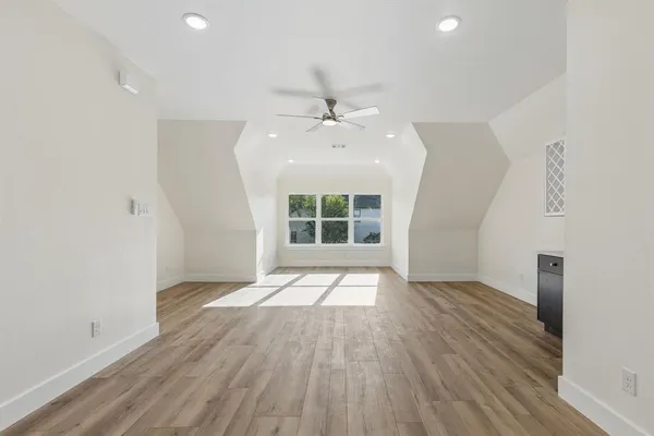 a view of empty room with wooden floor and ceiling fan