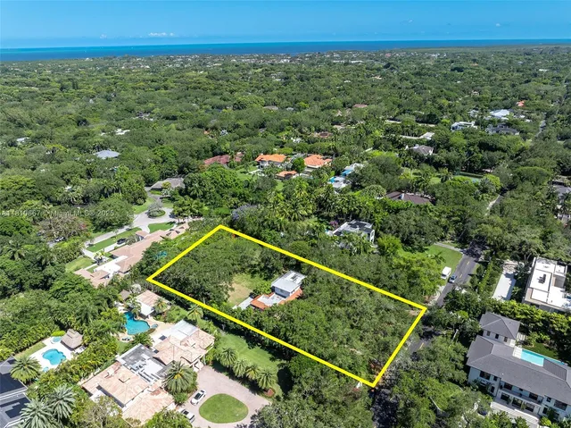 an aerial view of a residential houses with a yard and lake view