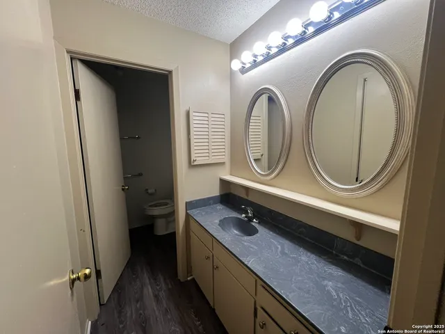 a bathroom with a granite countertop double vanity sink and a mirror