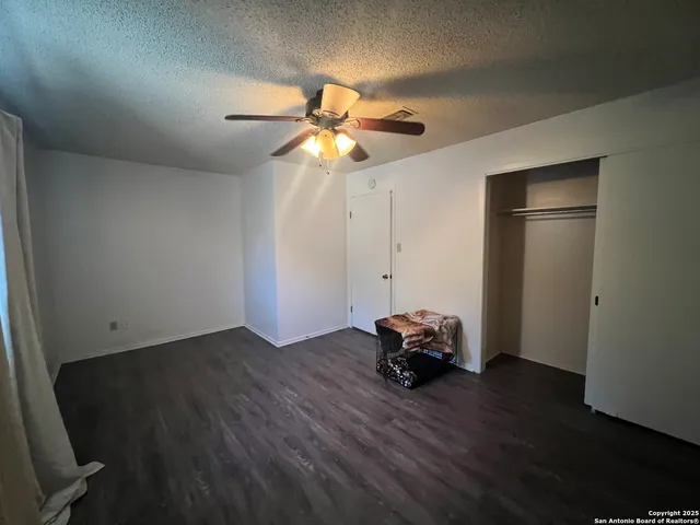 a view of a livingroom with wooden floor and a ceiling fan