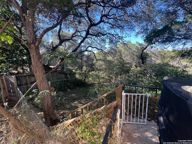 a balcony with wooden fence and trees