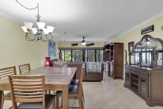 a view of a dining room with furniture a chandelier and wooden floor