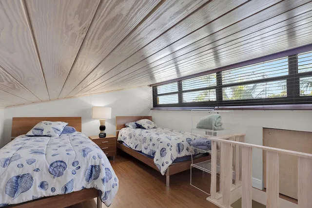 a bedroom with two beds and a large window