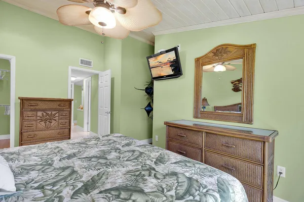 a bedroom with a bed and a mirror on the dresser