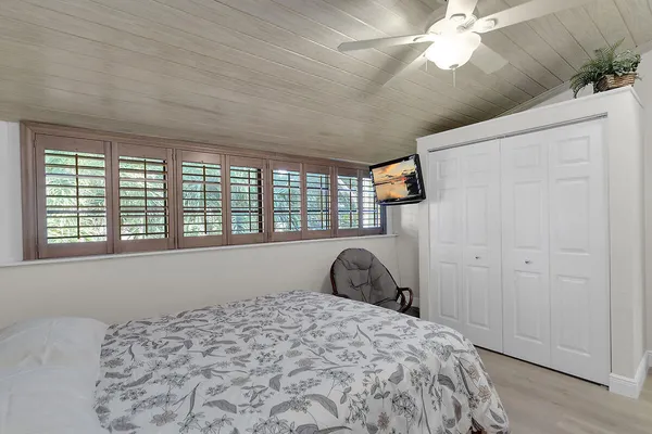 a bedroom with a bed and a large window